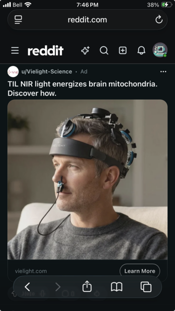 Screenshot of a Reddit ad from Vielight Science showing a man seated indoors wearing a futuristic-looking head-mounted device with several circular components positioned around his scalp and a small sensor clipped beneath his nose. The ad reads, “TIL NIR light energizes brain mitochondria. Discover how.” A “Learn More” button appears below the image.